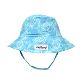UPF 50+ Bucket Hat - Tortuga Bay. Teal hat with dark teal turtle silhouettes, soft green palm trees, and white linework turtles. Velcro chin strap.