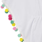 Close-up of a white garment with a decorative border of colorful pom-poms in pink, yellow, and green.