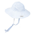 A light blue and white seersucker-striped floppy sun hat with a long, adjustable tie that extends from the sides and ties under the chin. Features a small “The Original Flap Happy” brand label on the brim.