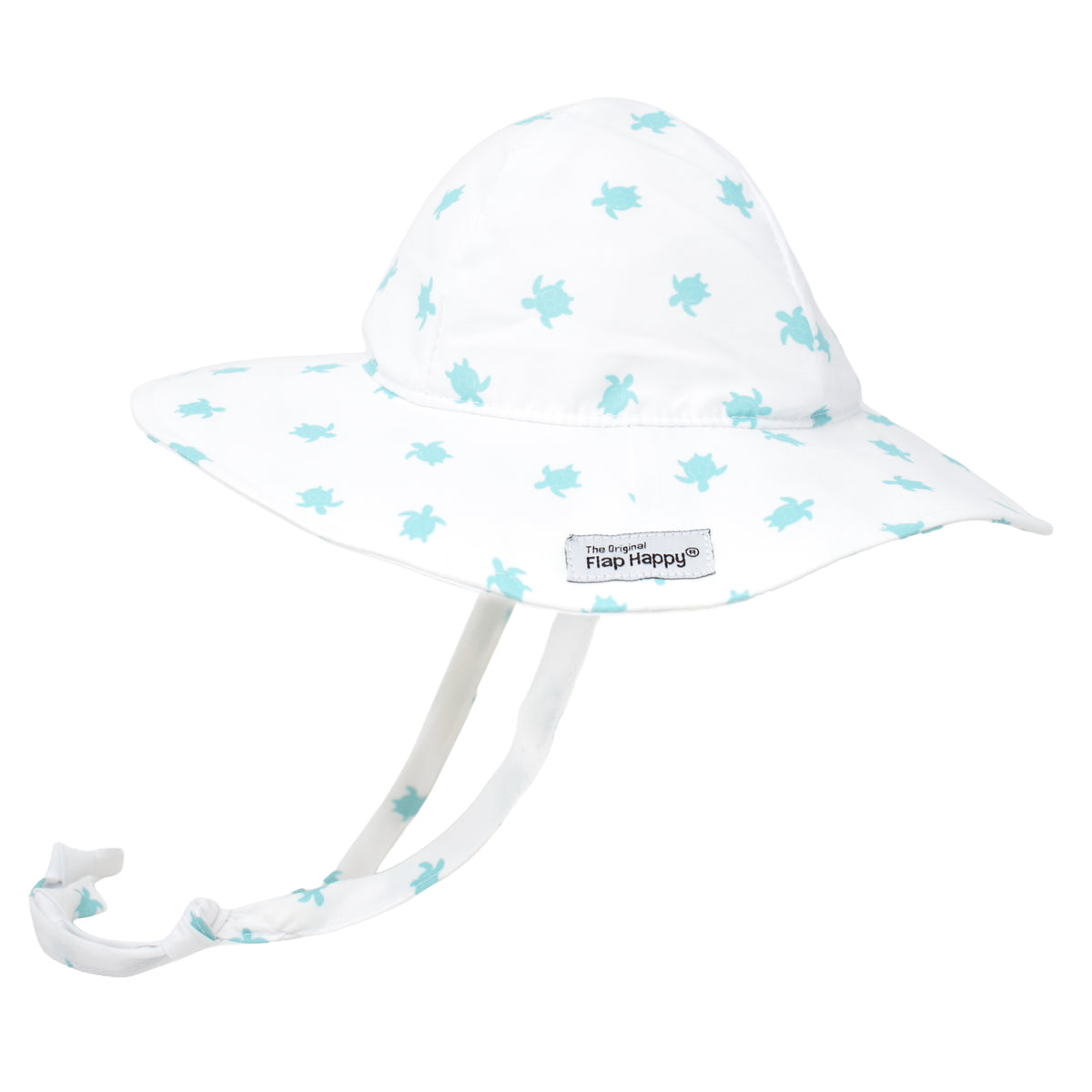 A white sun hat with a light turquoise turtle pattern, featuring a wide brim, an adjustable tie that extends from the sides and ties under the chin, and a small brand label reads “The Original Flap Happy” visible on the brim. 