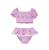 Flap Happy Kids UPF 50+ Sail Away Two Piece Smocked Pom-Pom swimsuit for sun protection. The Print is Pink with white, blue sail boats. also includes  bright yellow suns and rainbows.