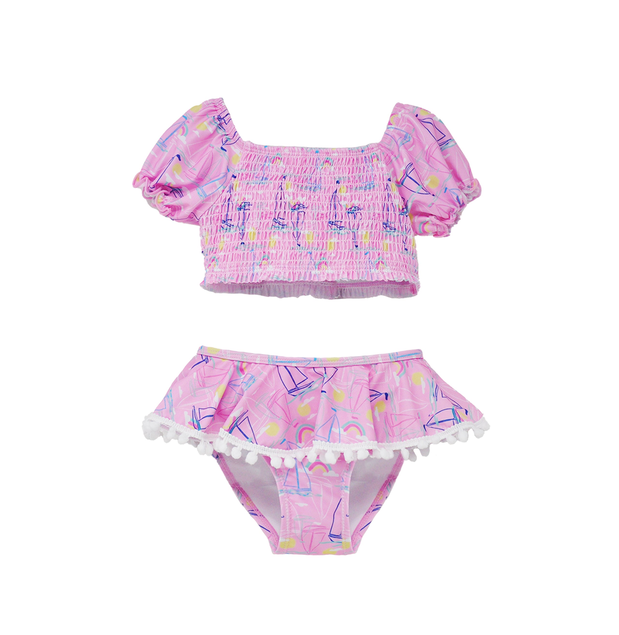 Flap Happy Kids UPF 50+ Sail Away Two Piece Smocked Pom-Pom swimsuit for sun protection. The Print is Pink with white, blue sail boats. also includes  bright yellow suns and rainbows.