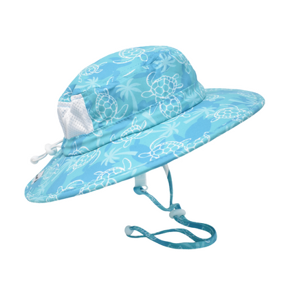 Kids UPF 50+ Kai Adventure Hat - Tortuga bay. Teal hat with dark teal turtle silhouettes, soft green palm trees, and white linework turtles. White mesh on back. White drawstring and clasps.