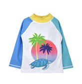 UPF 50+ Graphic Rash Guard Swim Top - Turtle Beach. White rash guard with light blue turtle graphic, palm trees, and sunset graphics on front. Blue right sleeve, teal left sleeve, and yellow neck.