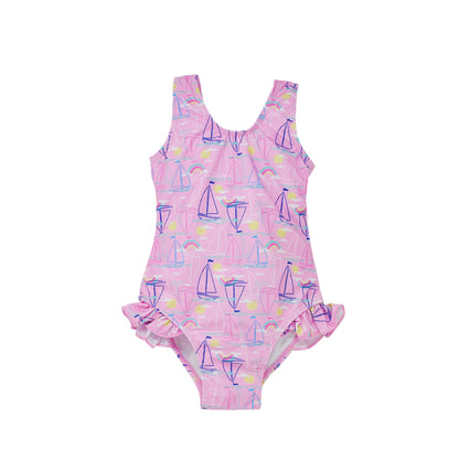 Flap Happy Kids UPF 50+ Infant hip Ruffle swimsuit in Sail Away for sun protection. The Print is pink with blue, pink and white sail boats. surrounded with bright yellow suns and rainbows. 