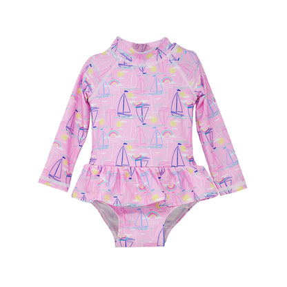  Flap Happy Infants UPF 50+ Ruffle Rash Guard swimsuit in Sail Away. The print has Blue and Pink colored  sail boats. With bright yellow sun and  small colorful rainbows.  