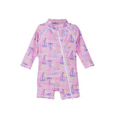 Flap Happy Kids UPF 50+ Shorties Surf Swimsuit in Sail Away for sun protection. The Print is pink with Blue, white and pink sailboats. Surrounded by yellow suns and rainbows.