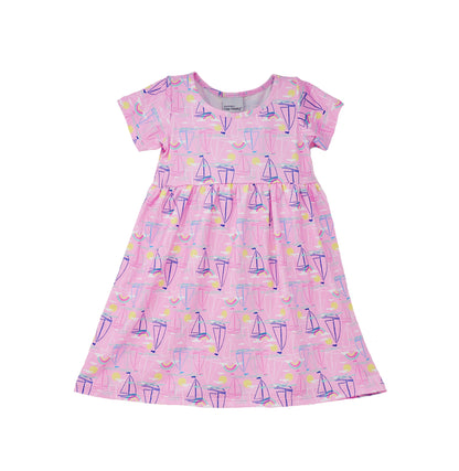 Flap Happy Kids UPF 50+ Short sleeve tee dress Sail Away for sun protection. The print has Blue, Pink and white sail boats. surrounded by bright yellow suns and color rainbows.